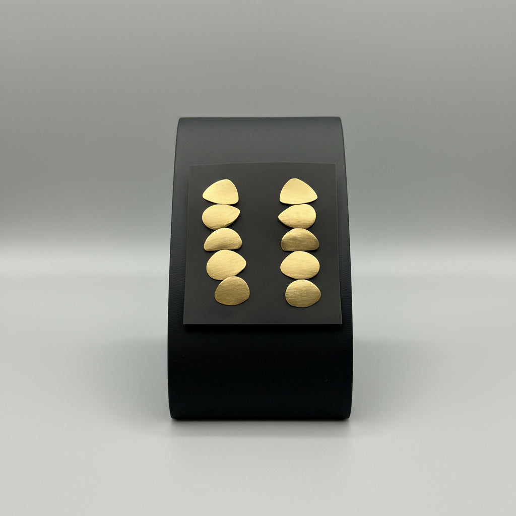 Pair of brass earrings on a dark background