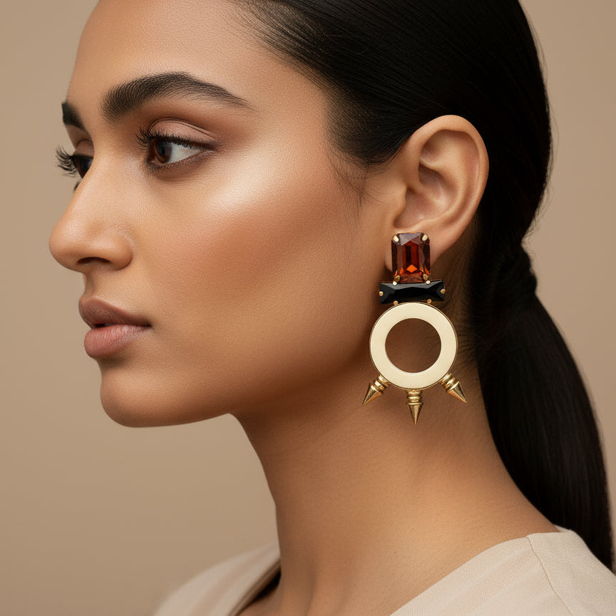 A pair of handcrafted stone earrings with circle designs displayed on a dark background.