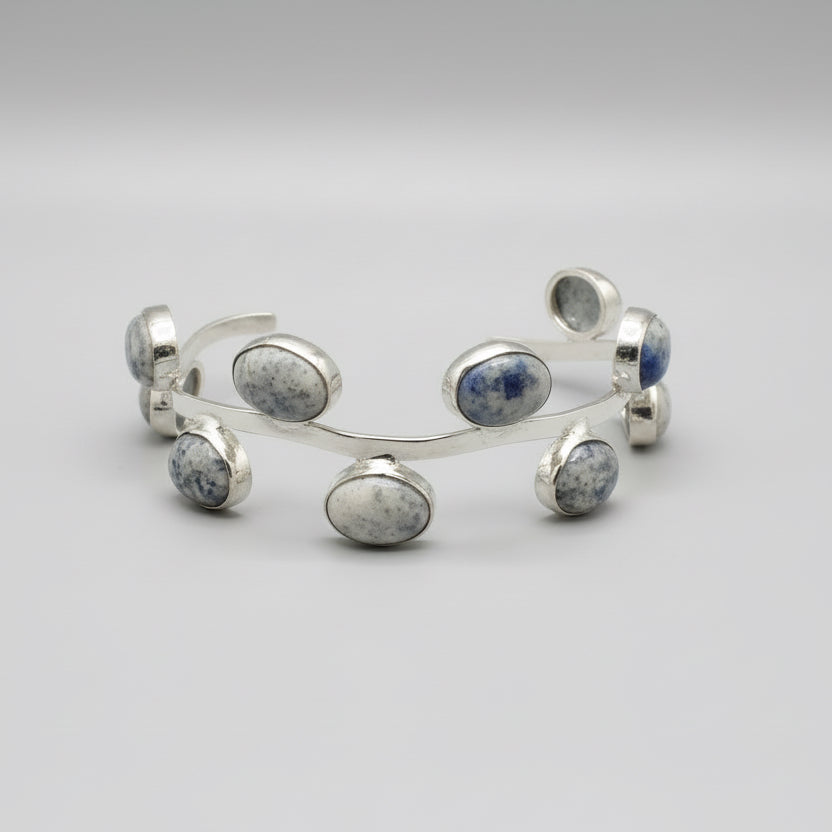Silver bracelet with stones on a gray fabric background