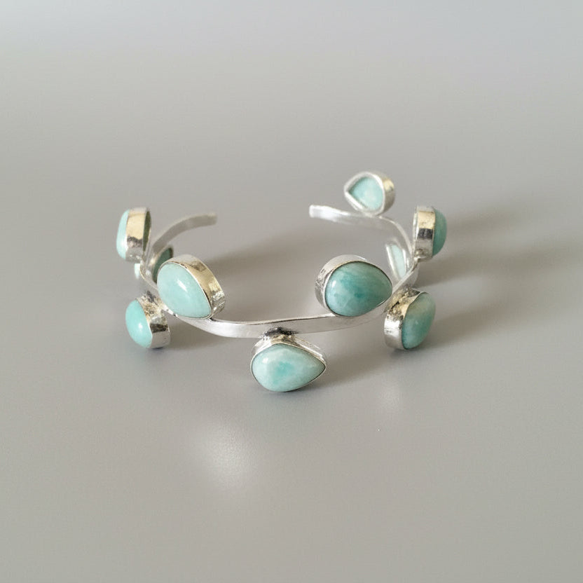 Silver earring with turquoise stones on a dark background