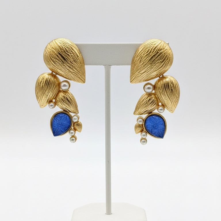Gold and blue brooches on a dark background