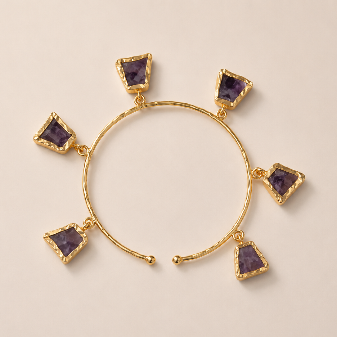 Gold  plated adjustable braceletpurple gemstones on a beige background