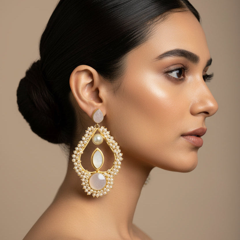 Woman wearing gold earrings with a neutral background