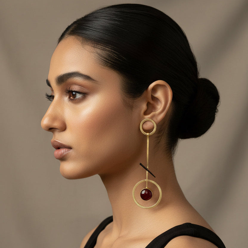 Woman wearing gold hoop earrings with a dark background