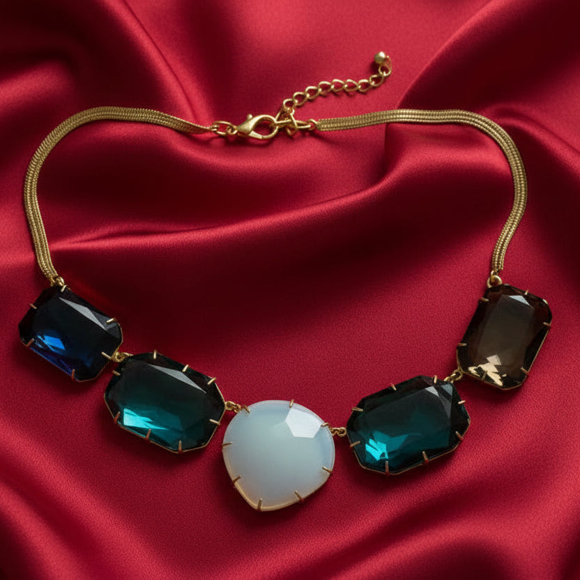 Necklace with green and blue gemstones on a beige background
