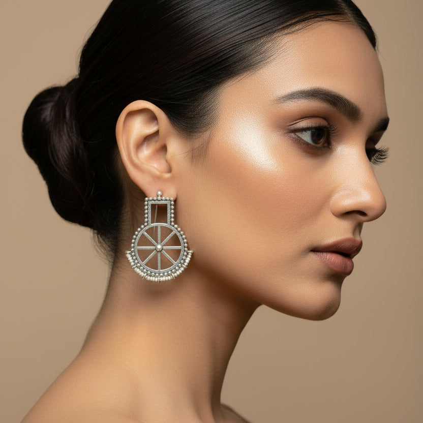 Pair of silver earrings on a dark fabric background