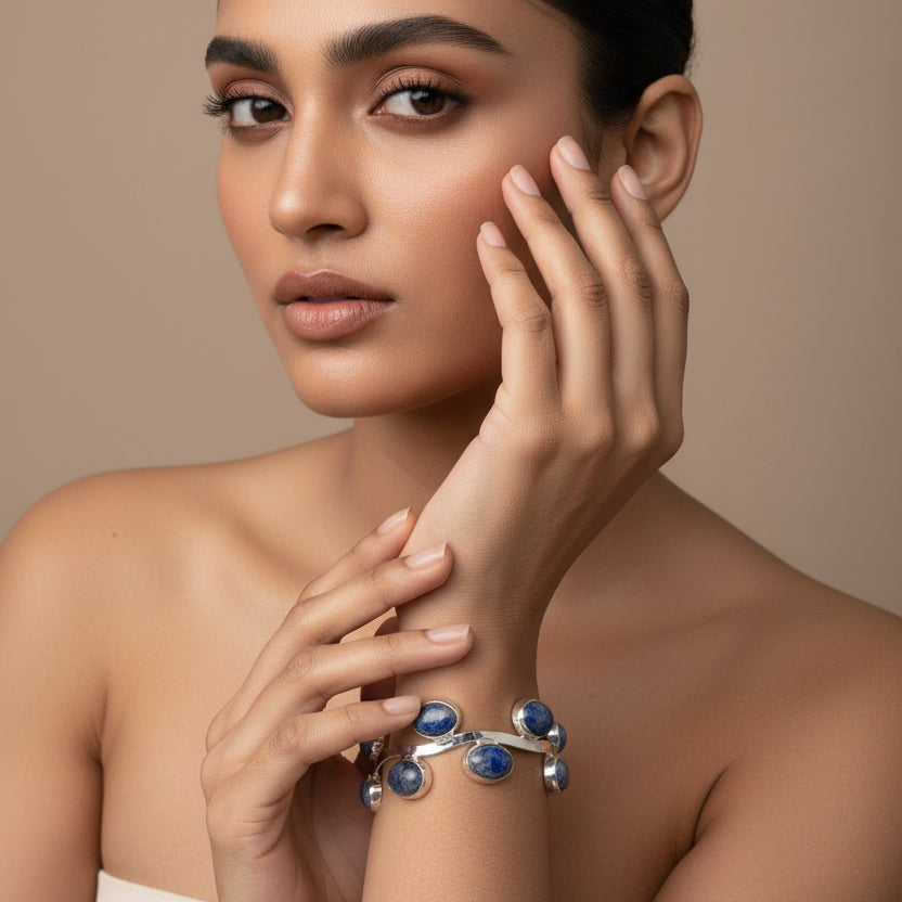Silver bracelet with blue stones on a wrist, with a blurred background