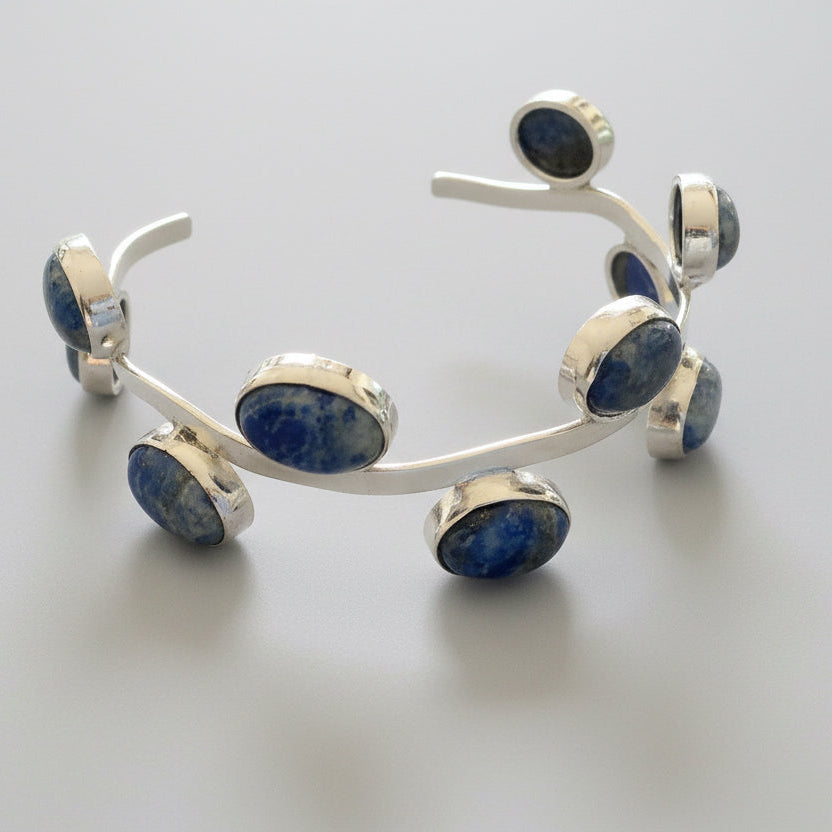 Silver bracelet with blue stones on a gray fabric background