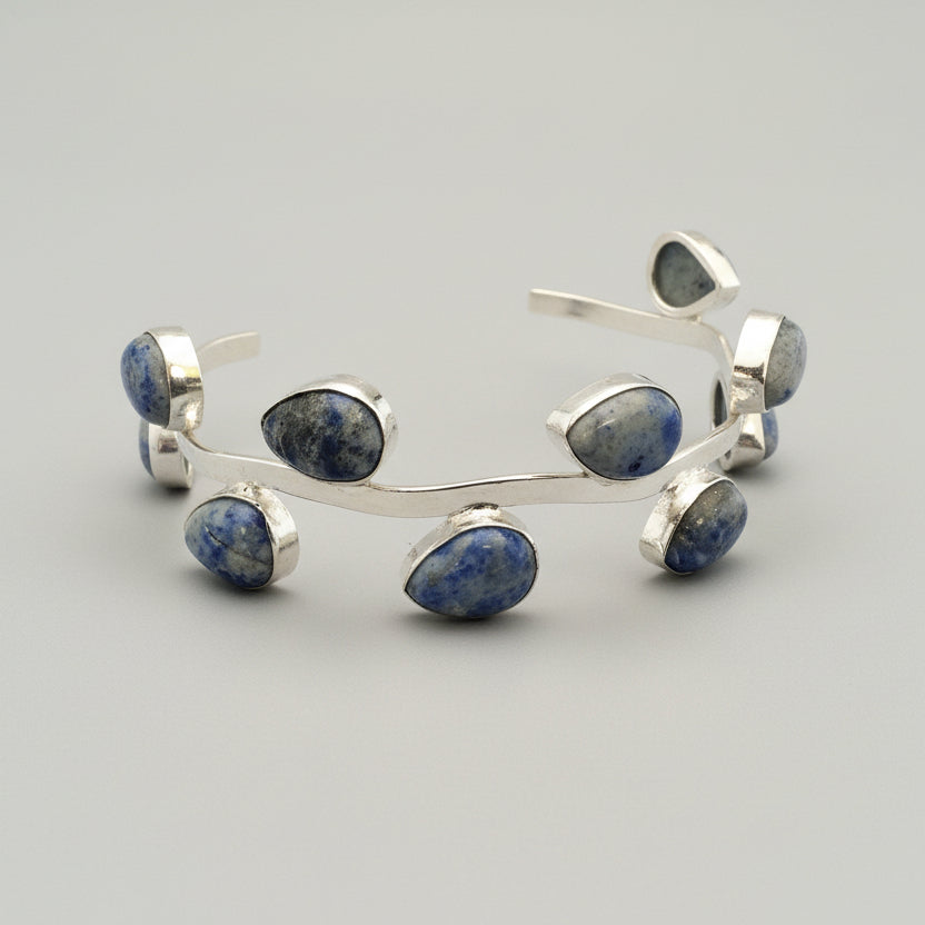 Silver headband with blue gemstones on a gray surface