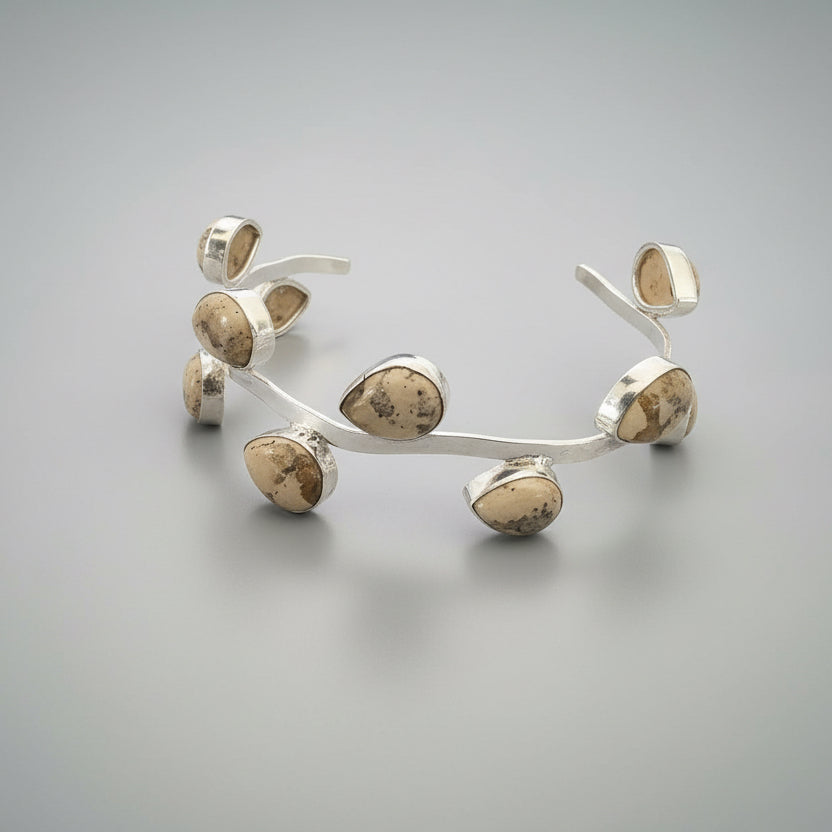 Silver leaf-like bracelet on a dark surface