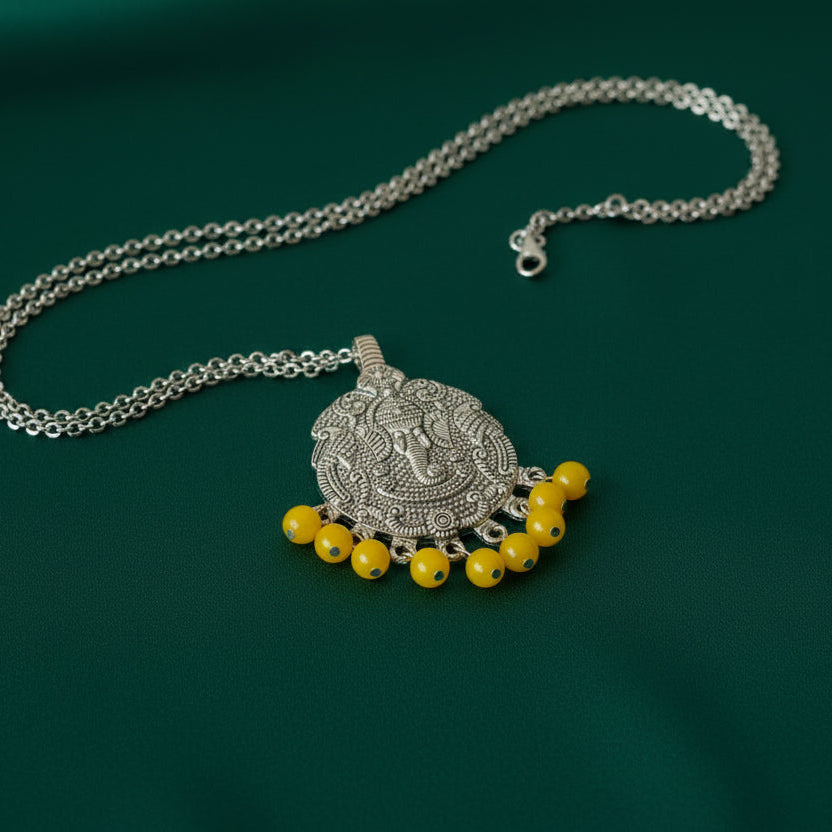 Decorative pendant with yellow beads on a black fabric background