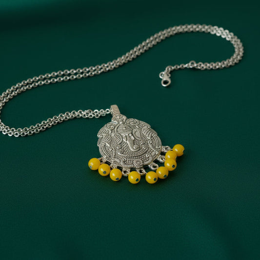Decorative pendant with yellow beads on a black fabric background