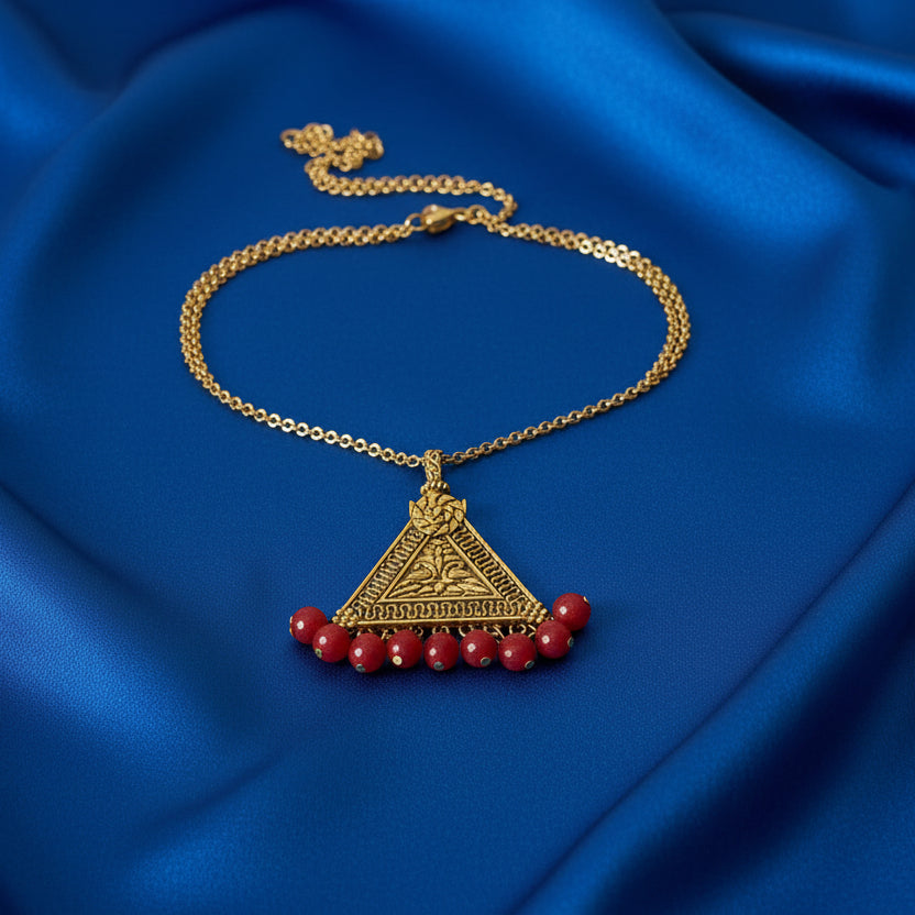 Decorative brooch with red beads on a black fabric background