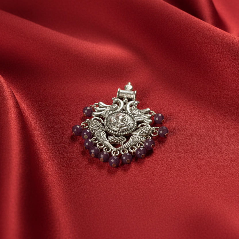 Decorative brooch with purple beads on a black fabric background