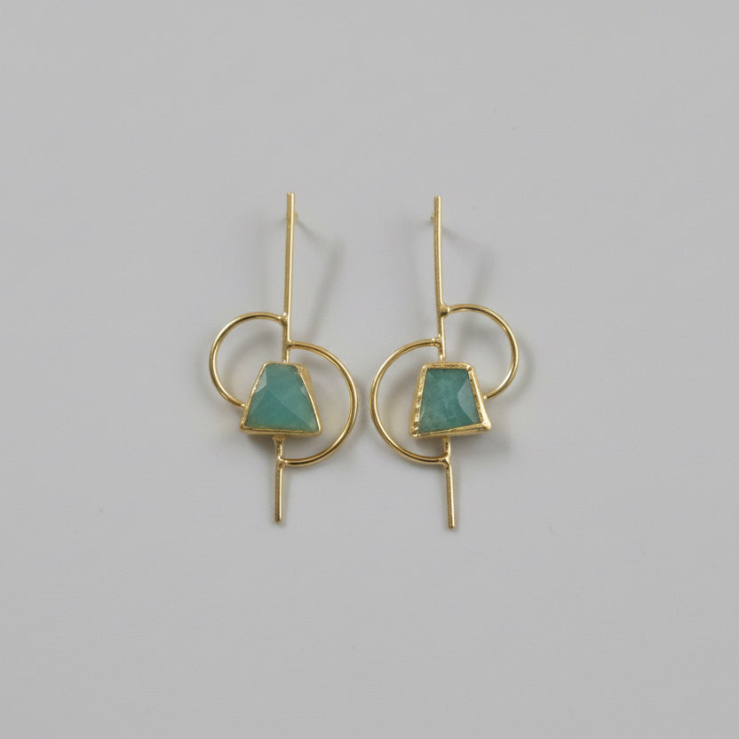 Pair of earrings with geometric design on a black fabric background