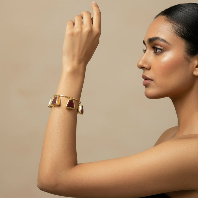 Red Stone bracelet with triangle-shaped brown charms on a black background