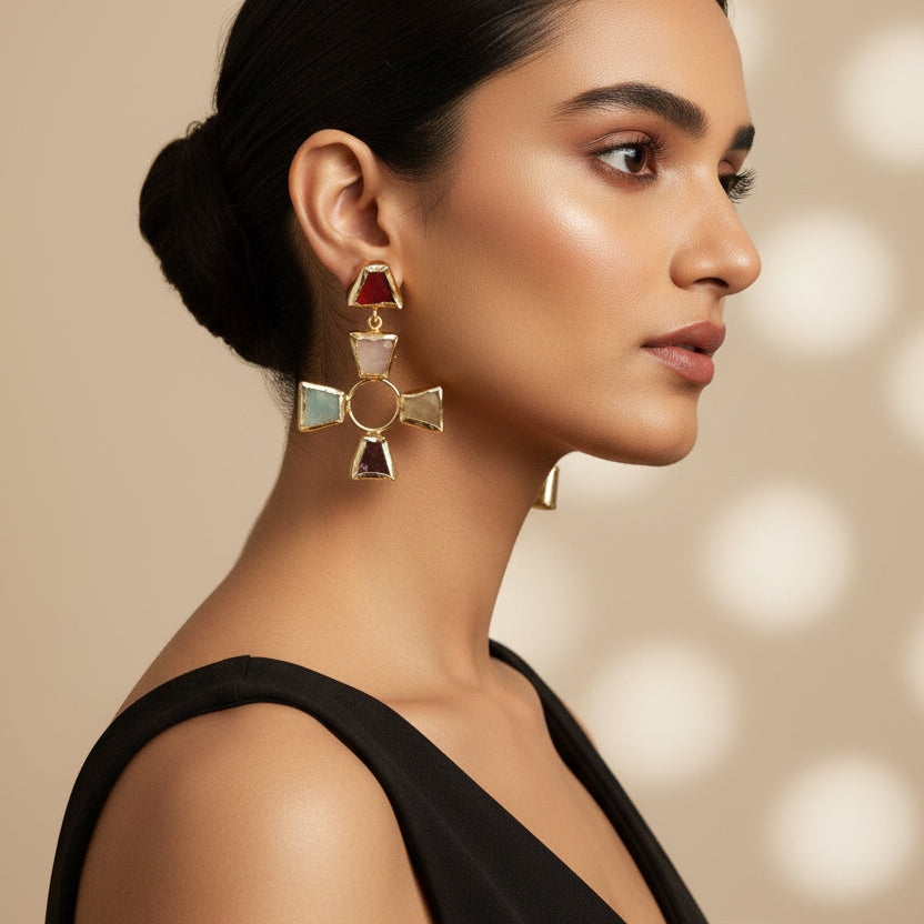 Pair of earrings with cross design on a black surface with a green striped background