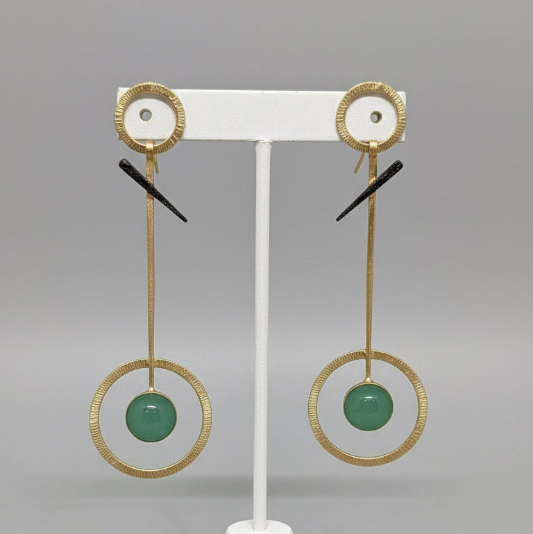 Pair of earrings on a black card with a textured surface background
