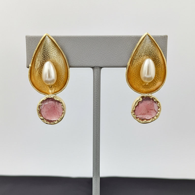Gold and red teardrop-shaped earrings on a black card