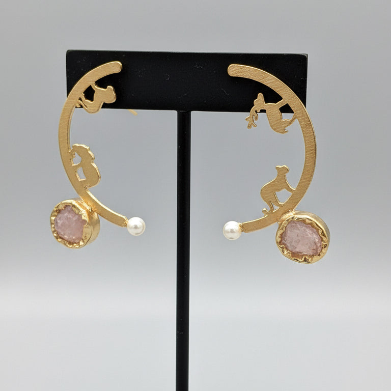 Gold earrings with gemstones on a black card