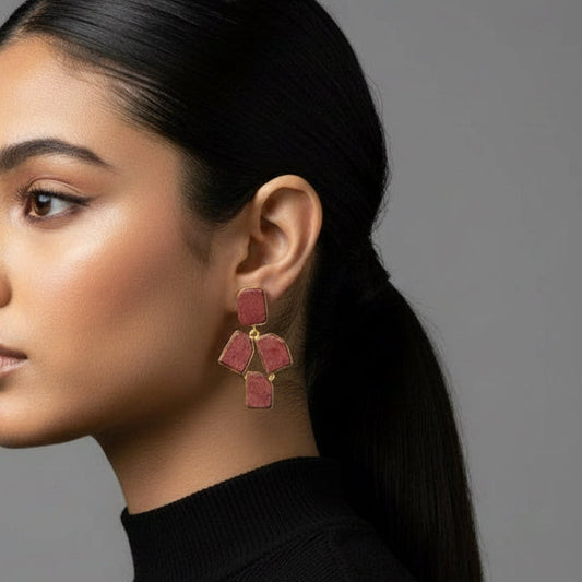 Pair of earrings with geometric red and gold design on a black background