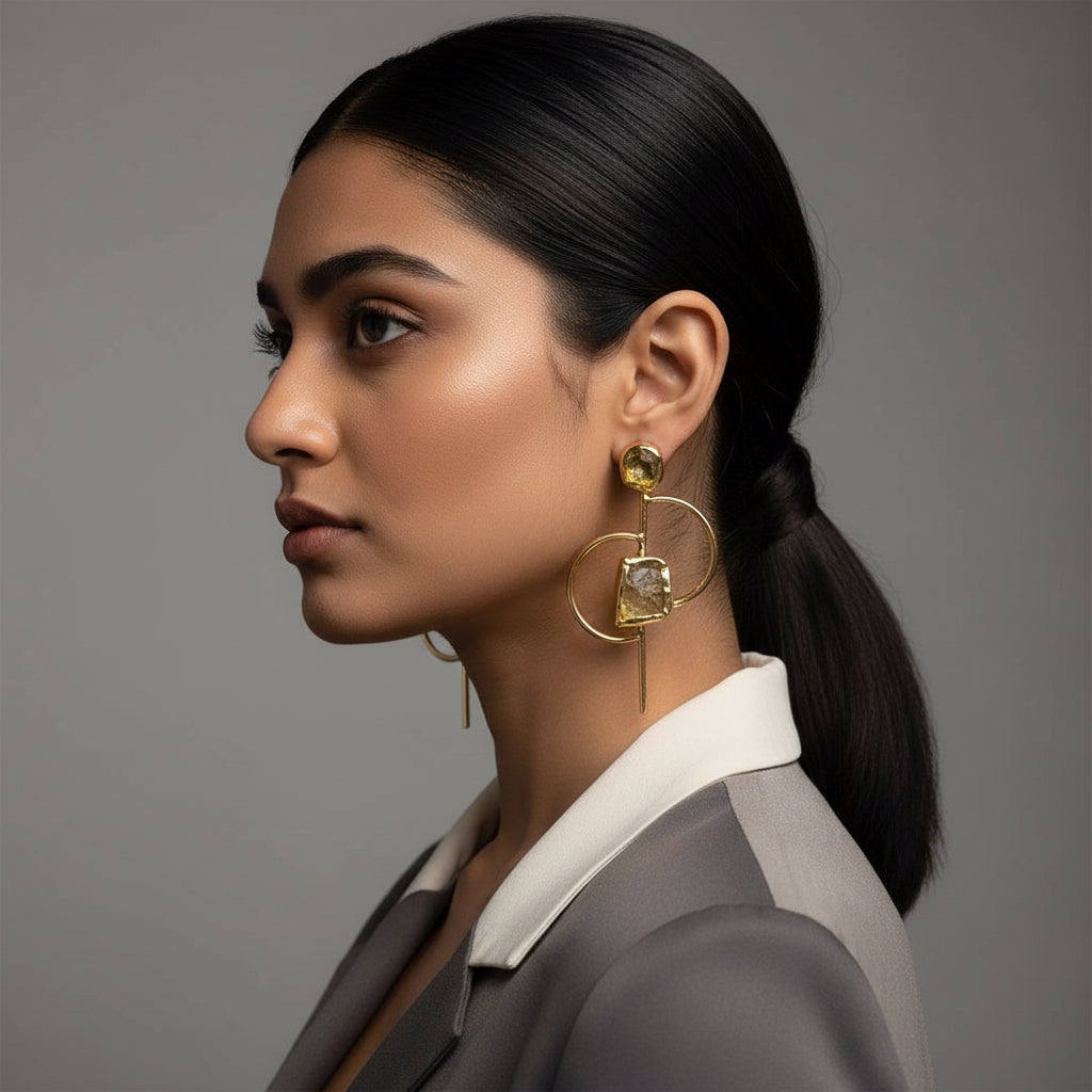 Gold earrings with circular designs and embedded stones on a dark background