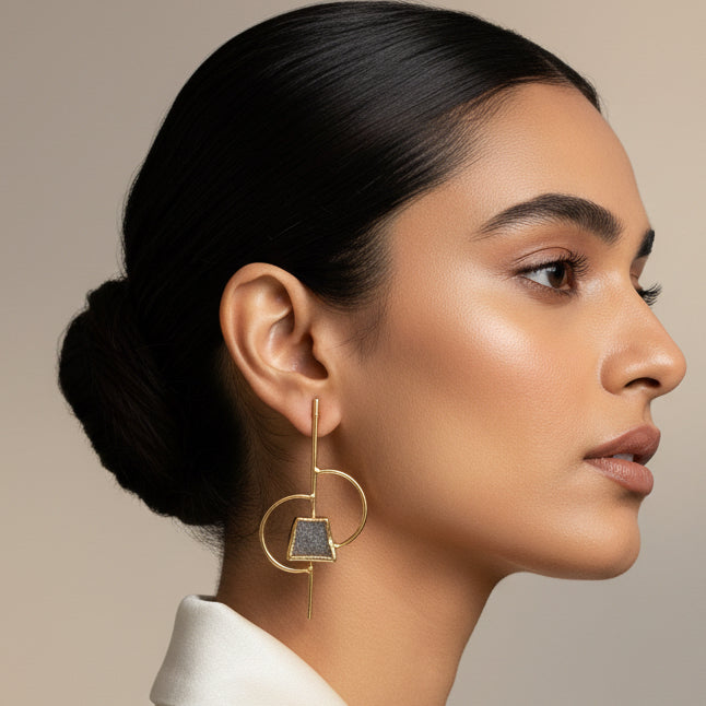 Gold hoop earrings with square gemstones on a black background