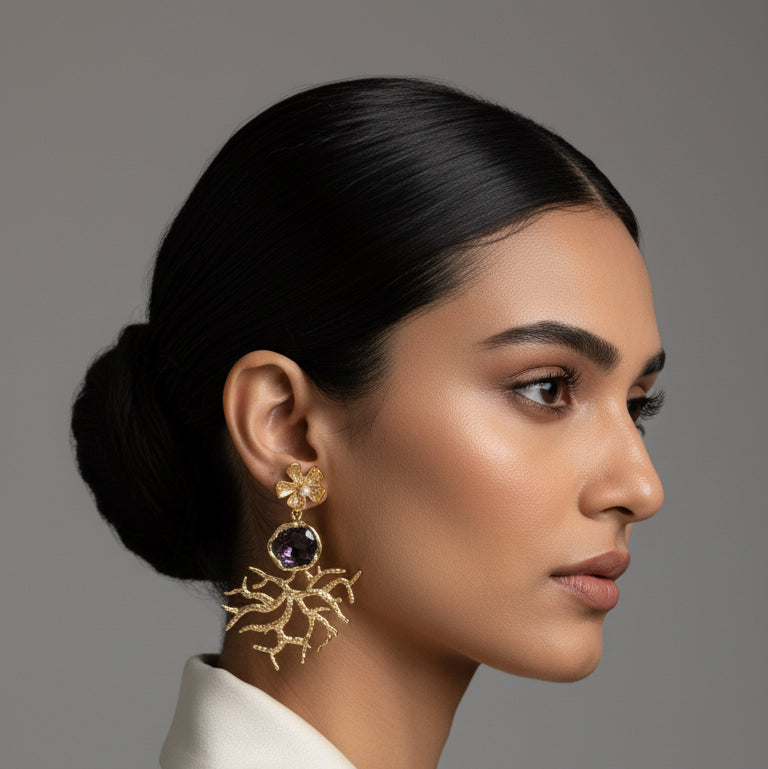 Pair of gold and black earrings on a black card against a dark background