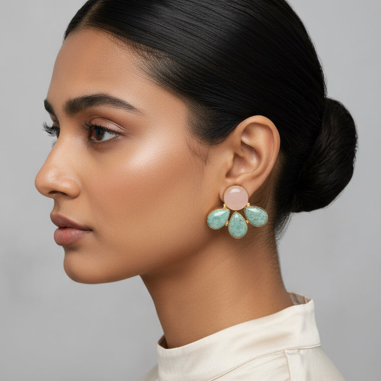 Pair of earrings with pink and green stones on a black card
