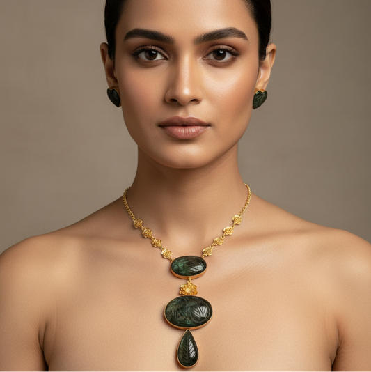 Necklace with black stones and gold accents on a textured gray background