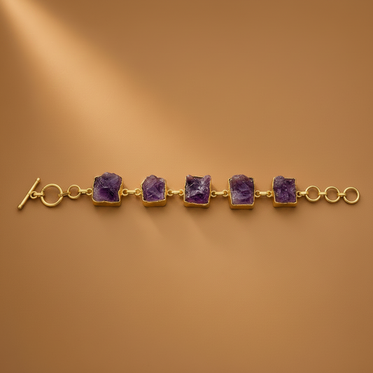 Gold bracelet with triangular brown stones on a brown background