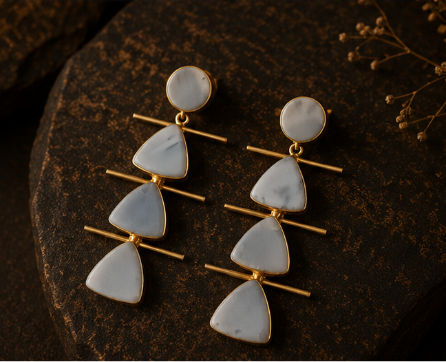 Three-panel product photo of statement dangle earrings. The left panel shows the earrings hanging on a gold display stand against a dark brown background.