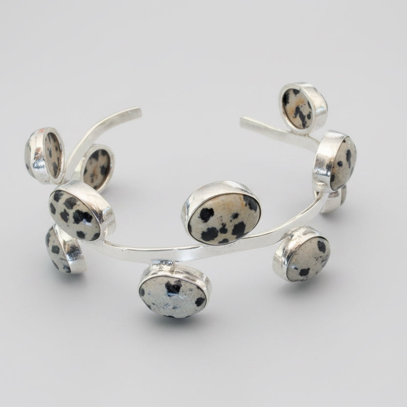 Silver bracelet with circular elements on a dark background
