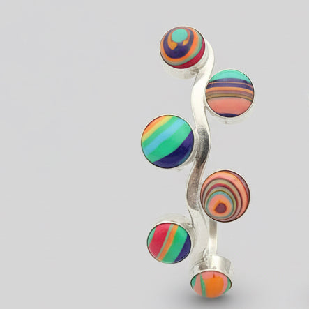 Colorful beaded earrings on a dark fabric background