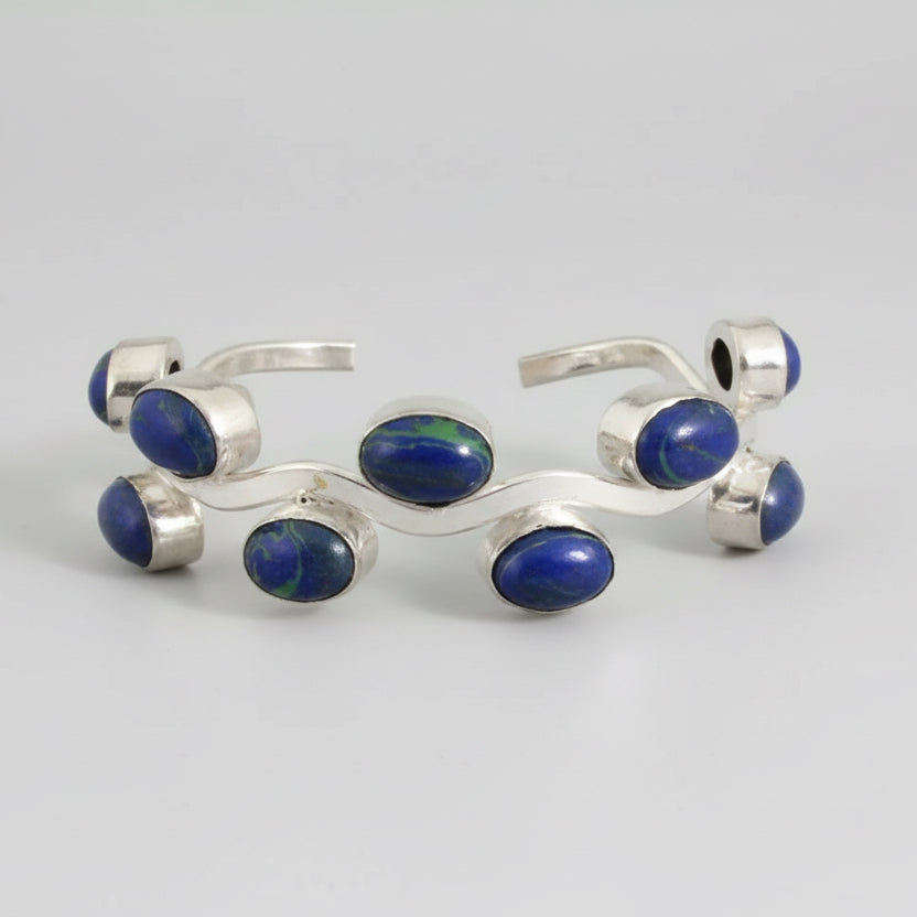 Silver bracelet with blue stones on a dark surface