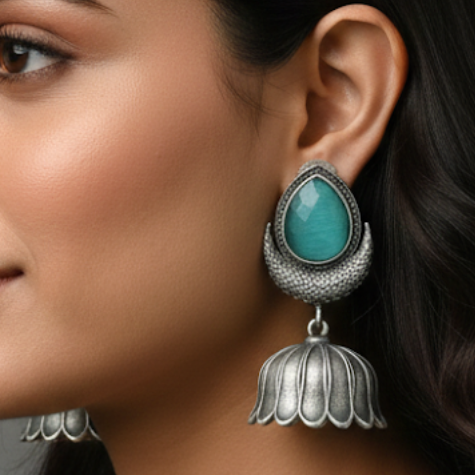 Close-up of a woman wearing silver earrings with turquoise stones.