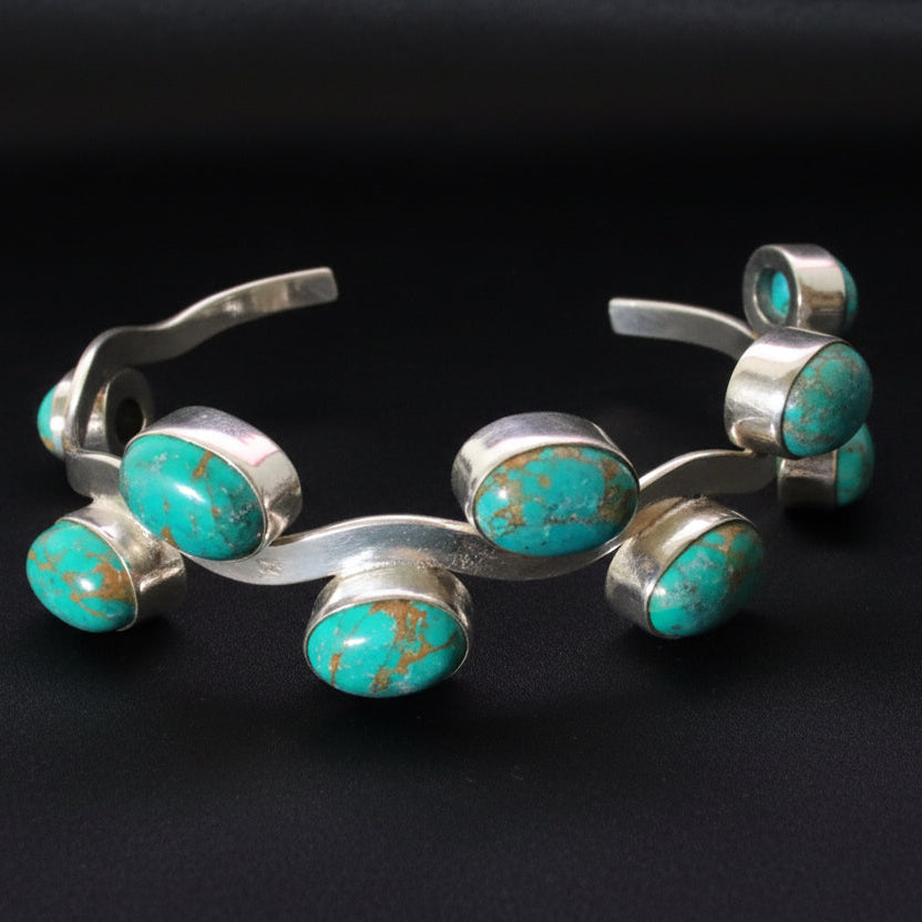 Silver bracelet with turquoise stones on a black background