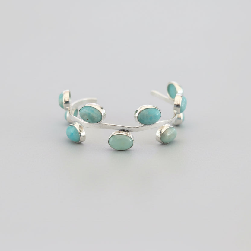 Silver bracelet with turquoise stones on a dark fabric background