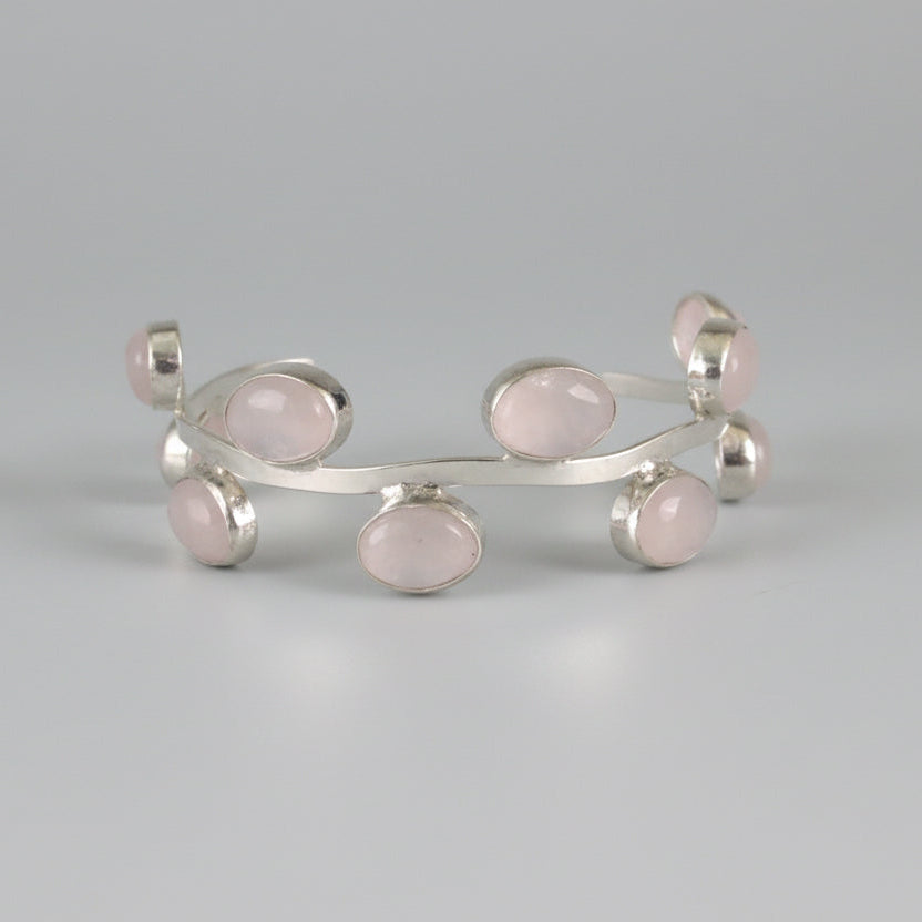 Silver bracelet with round components on a black surface