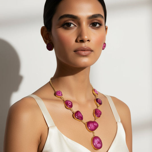 Woman wearing a necklace with pink gemstones against a neutral background